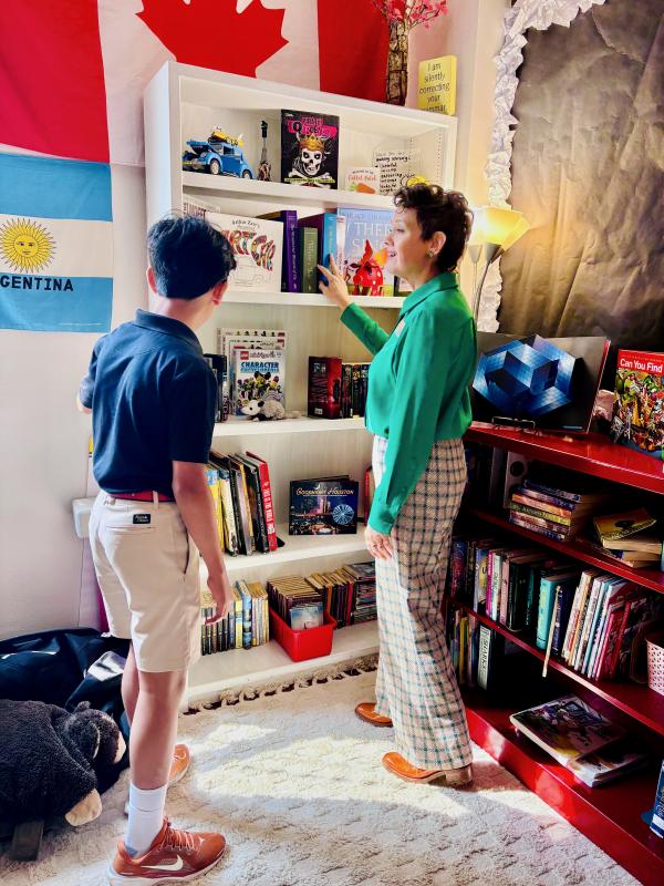 Ms. Caraway showing Kush her classroom library Kush with Ms. Caraway in her library
